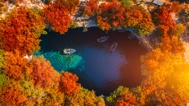 Bovenaanzicht van het magische meer van Melissani, tussen de bomen door
